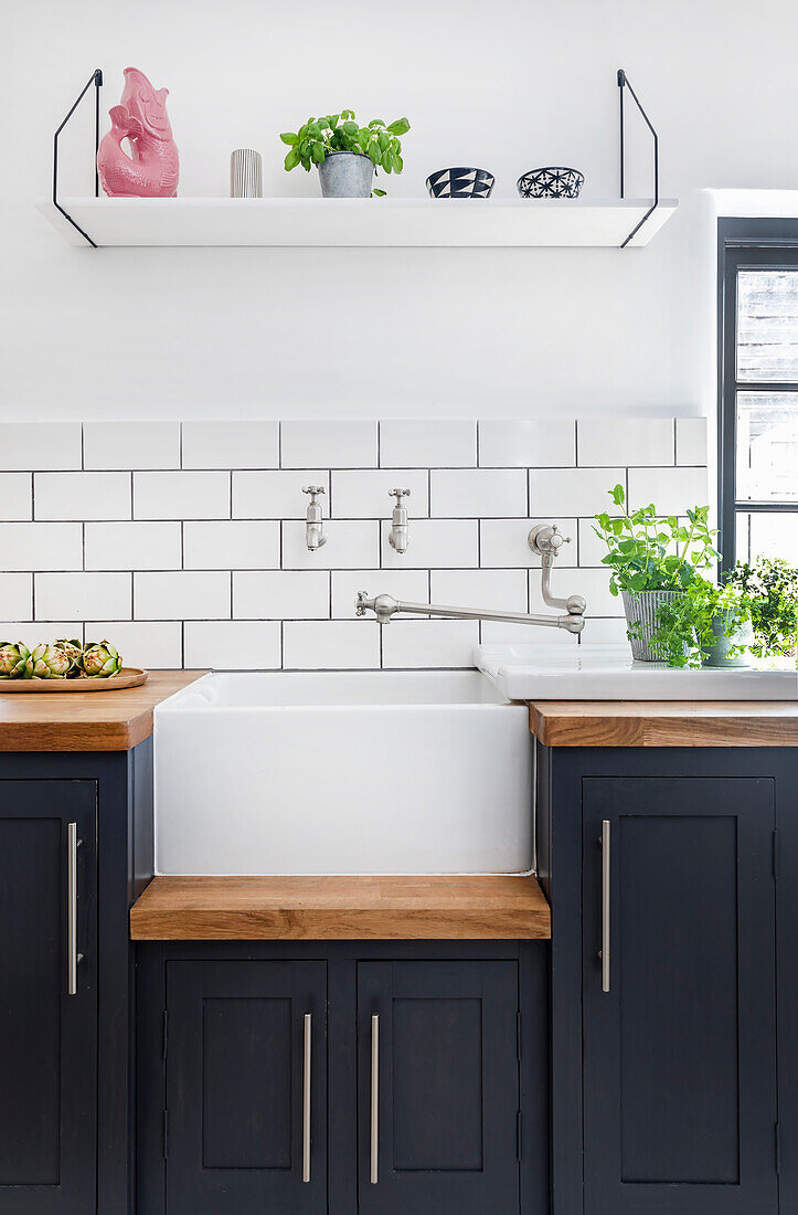 Country kitchen with sink, wooden worktops and white metro tiles