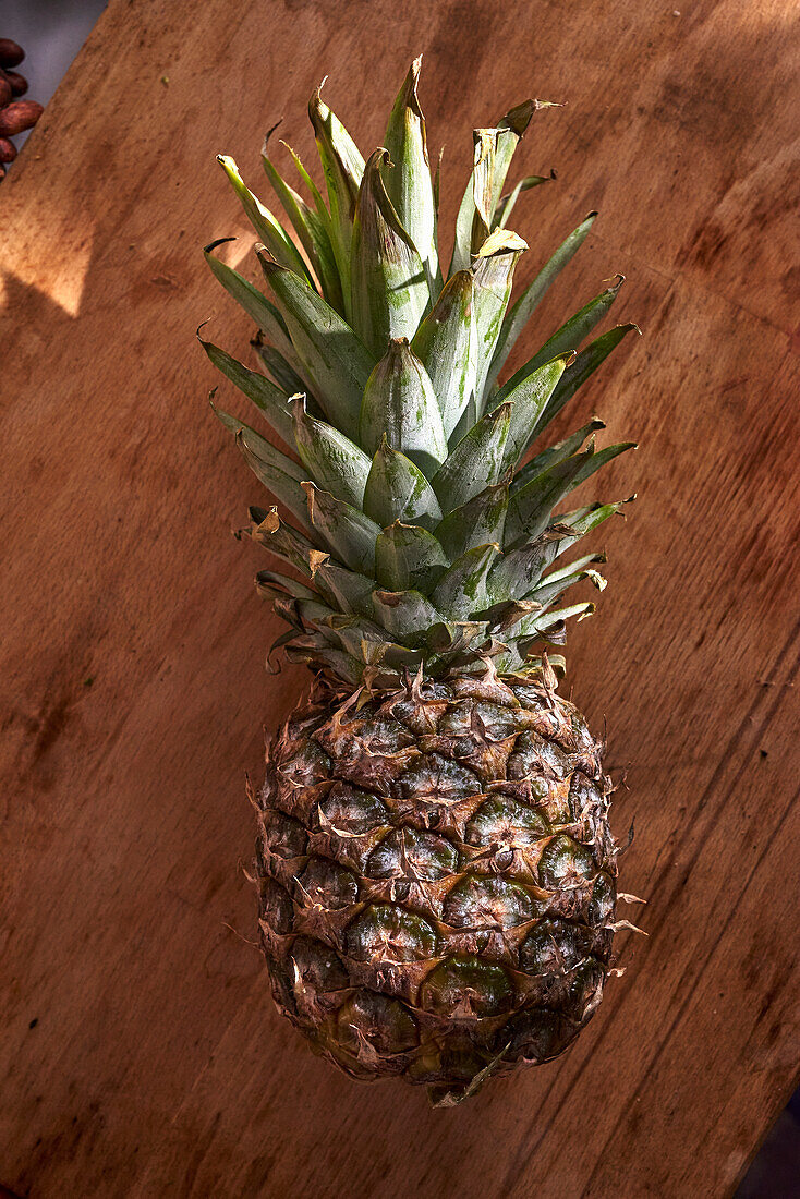 Whole pineapple on a wooden board