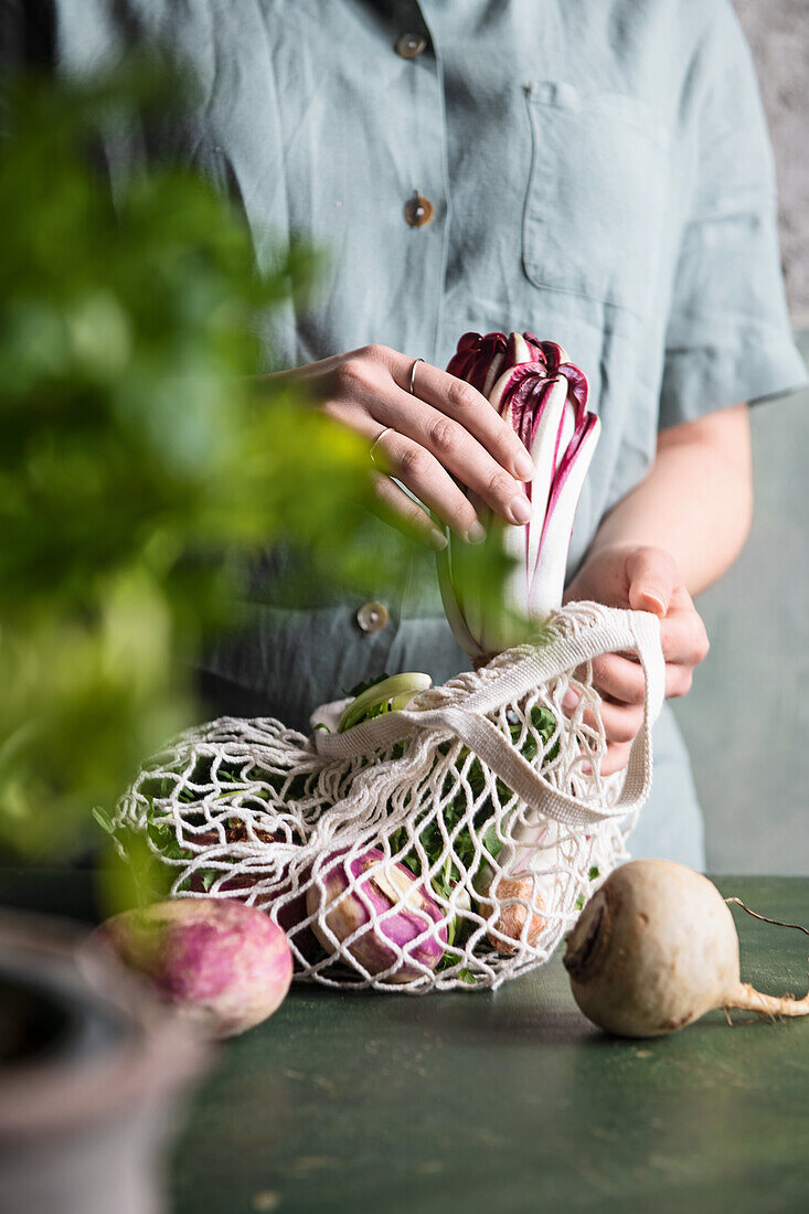 Frau hält Einkaufsnetz mit frischem Gemüse