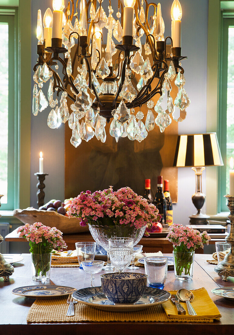 Set dining table with pink flower arrangements and chandelier