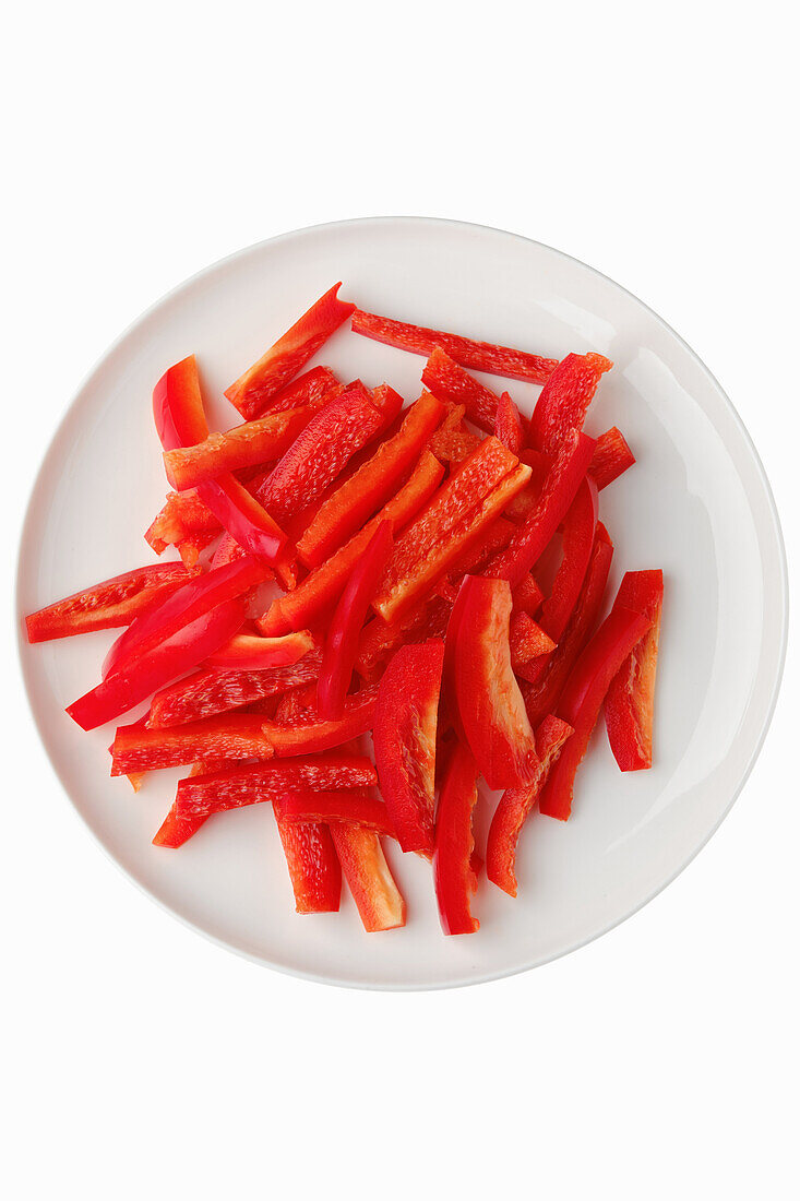 Sliced red pepper strips on a white plate