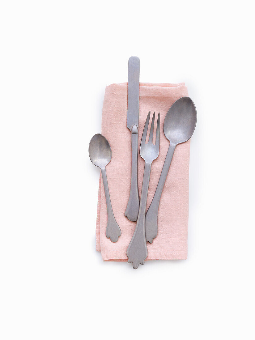 Cutlery on pink cloth napkin