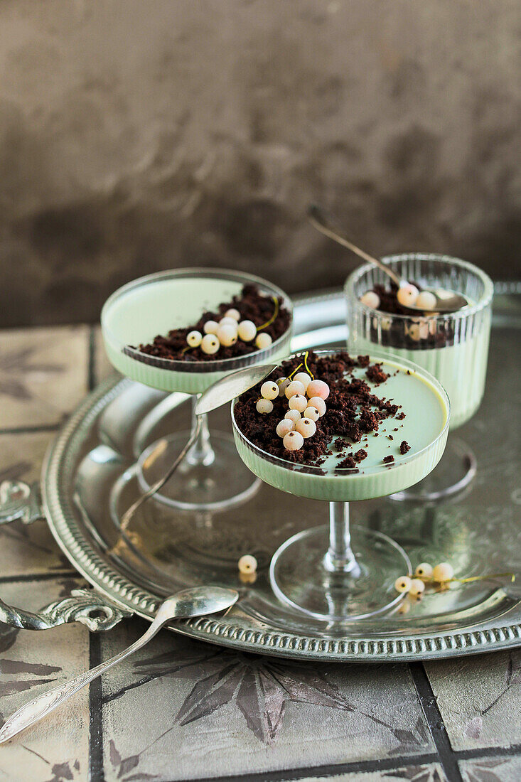 Matcha panna cotta with biscuit crumbs and redcurrants