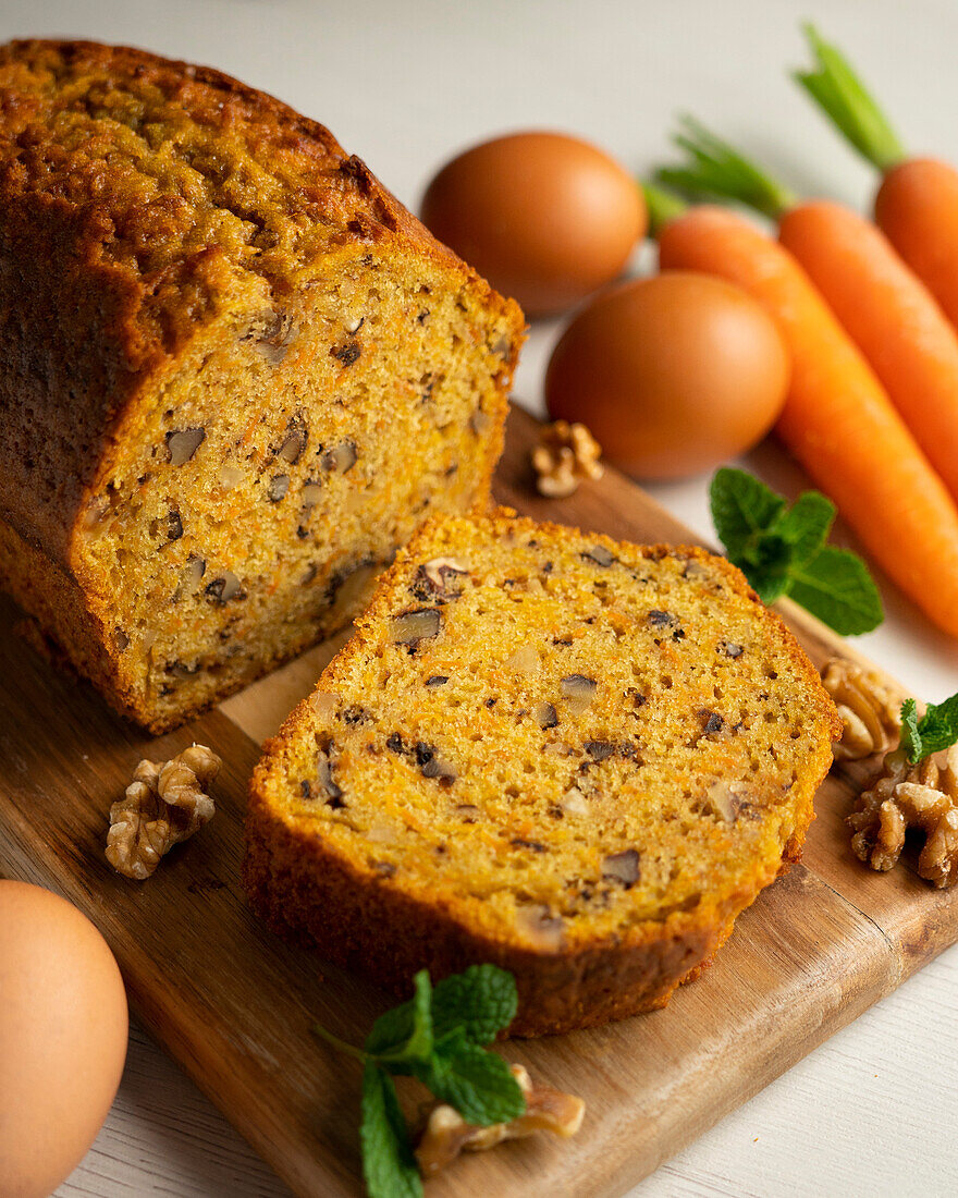 Carrot cake with nuts, eggs and carrots in the background