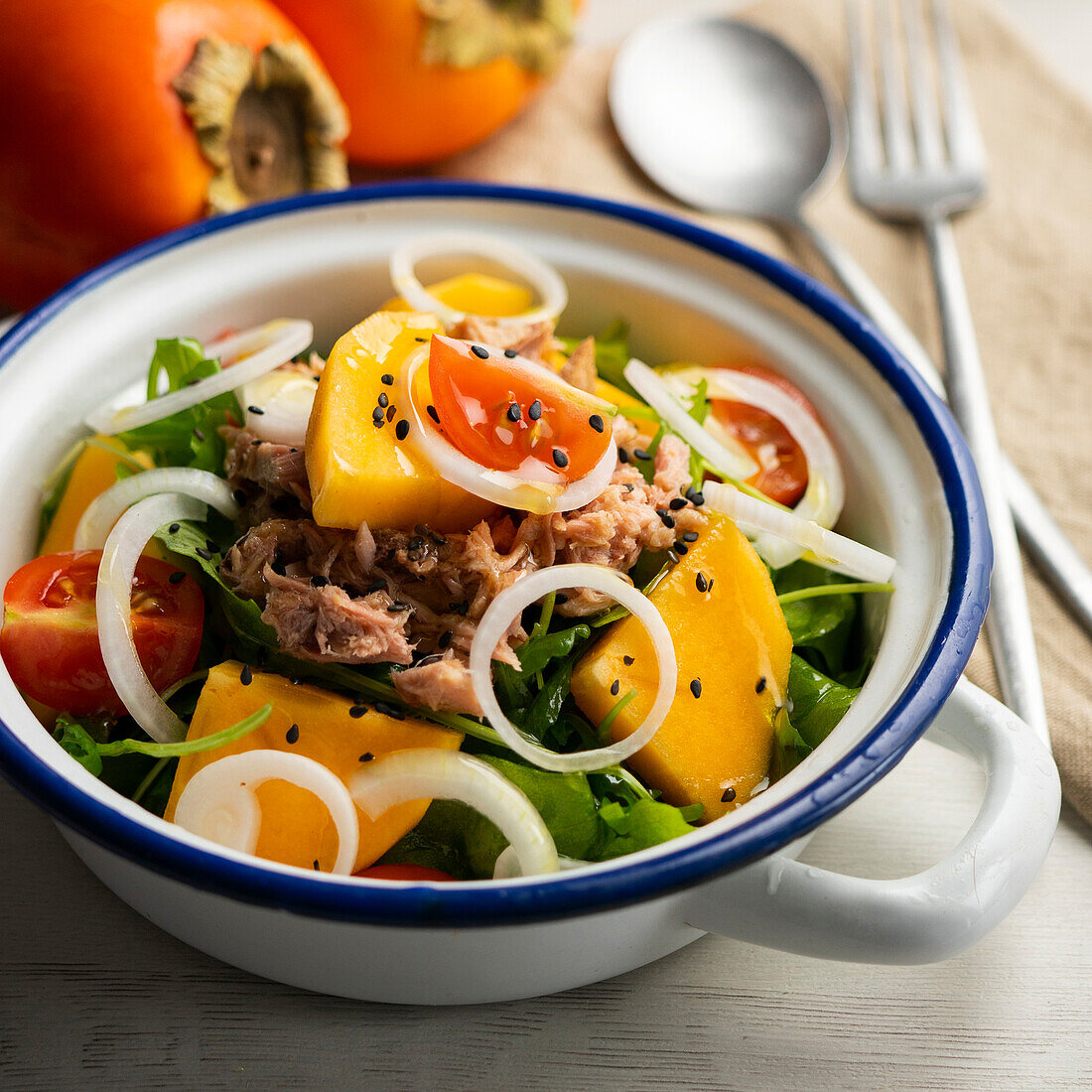 Salad with persimmon, tuna and tomatoes