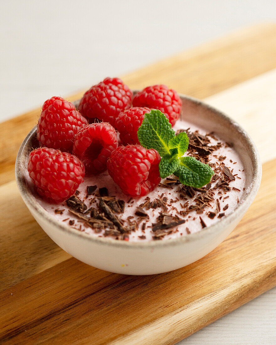 Raspberry mousse with fresh raspberries and chocolate shavings