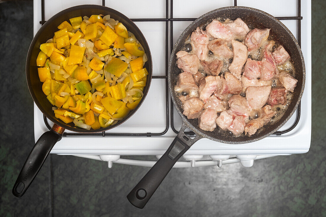 Angebratenes Schweinefleisch und Paprika-Zwiebel-Gemüse in Pfannen