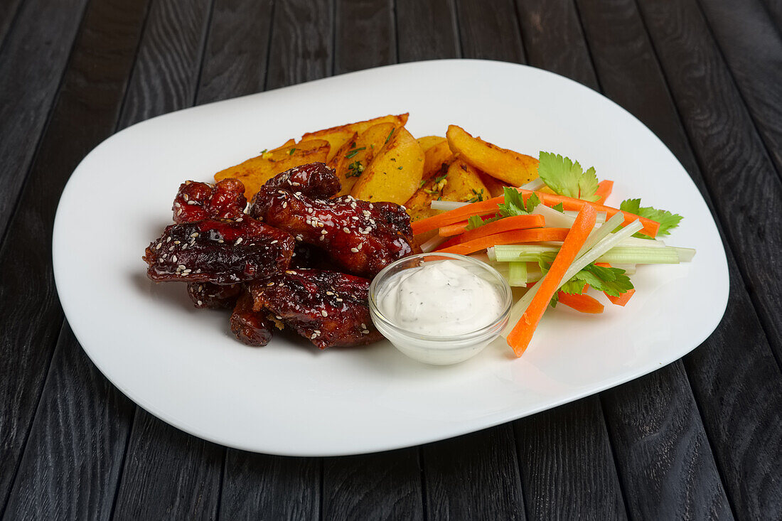 Buffalo Chicken Wings mit Pommes, Gemüsesticks und Dip