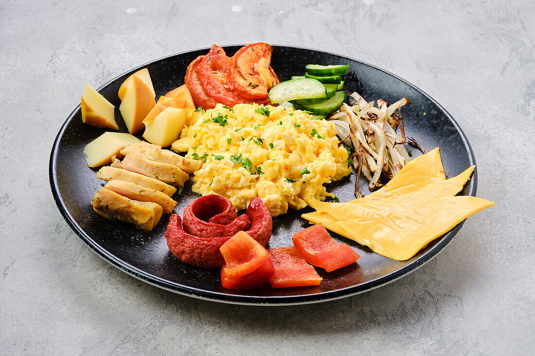 Scrambled eggs with meat, cheddar, peppers and roasted onions