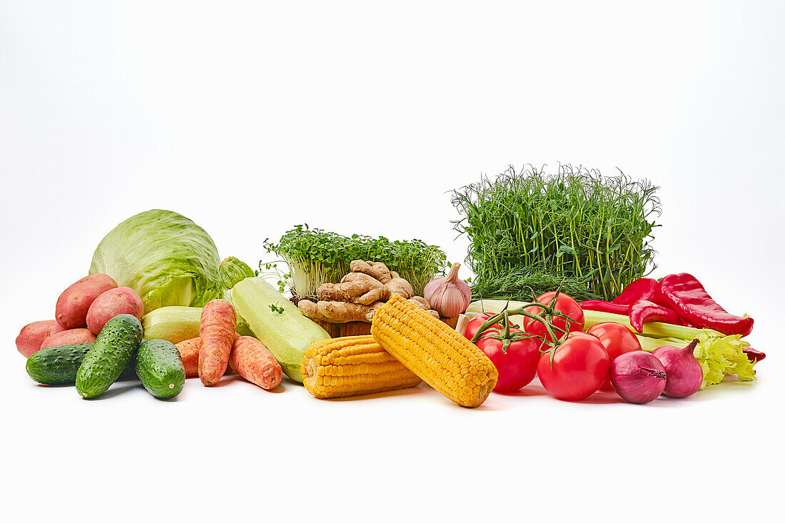 Various vegetables and herbs against a white background