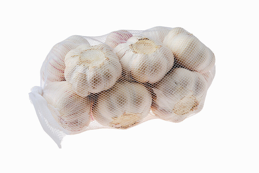 Net with garlic bulbs against a white background