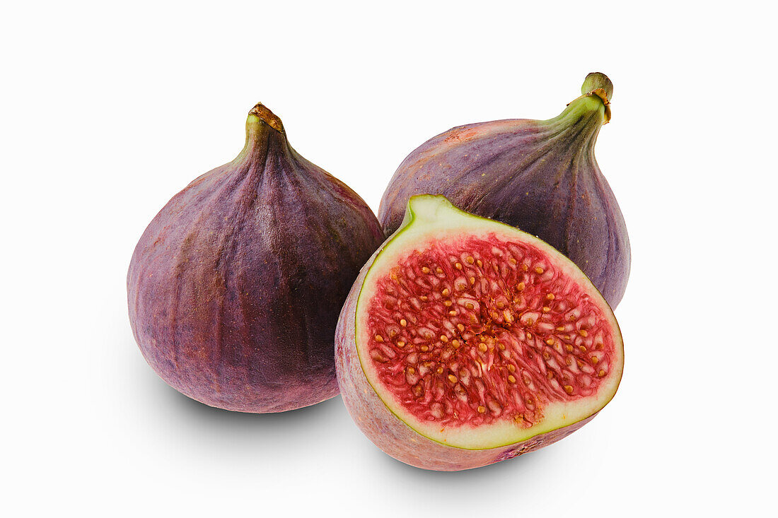 Whole and sliced figs against a white background