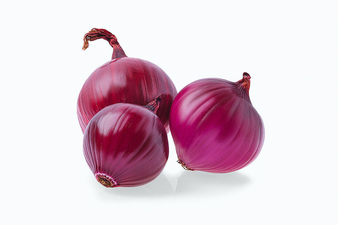 Three red onions against a white background