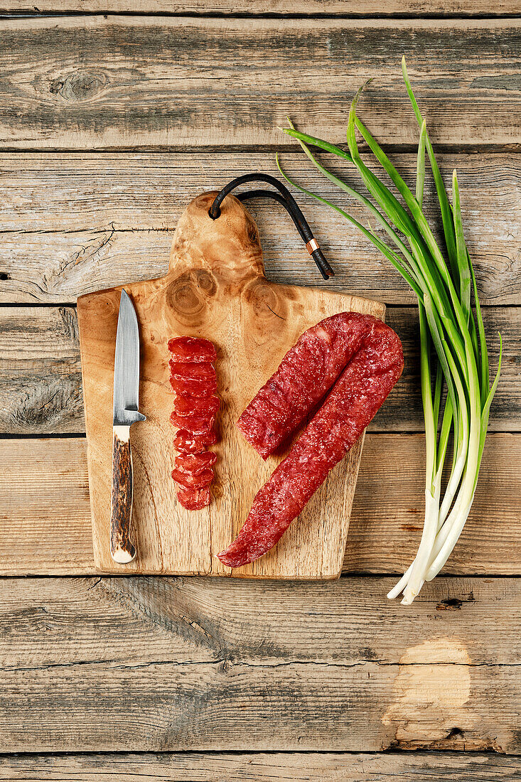 Geräucherte, luftgetrocknete Putenwurst am Stück und aufgeschnitten