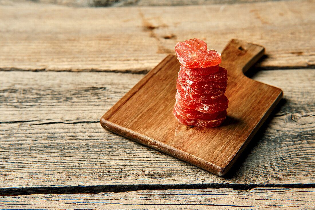 Slices of air-dried turkey sausage on a wooden board