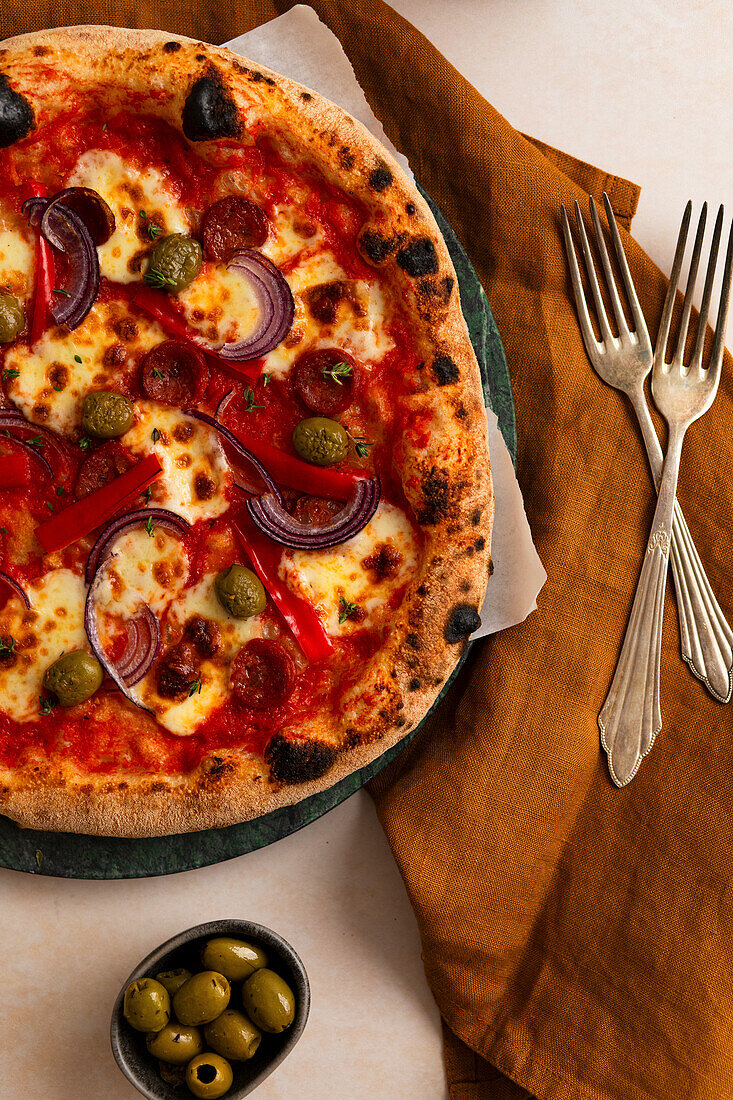 Pizza Diavolo mit Salami, Oliven, Paprika und roten Zwiebeln