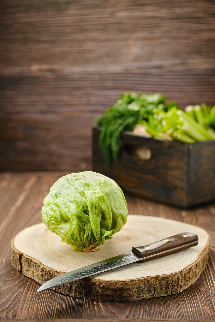 Eisbergsalat mit Messer auf Holzschneidebrett