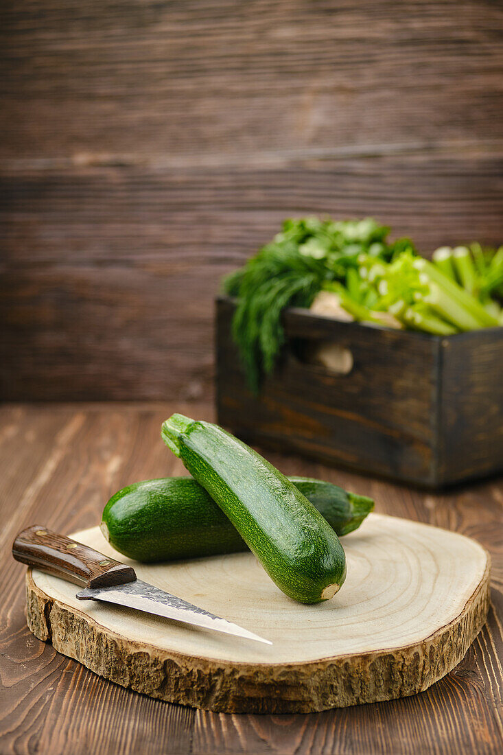 Zucchini mit Messer auf Holzschneidebrett