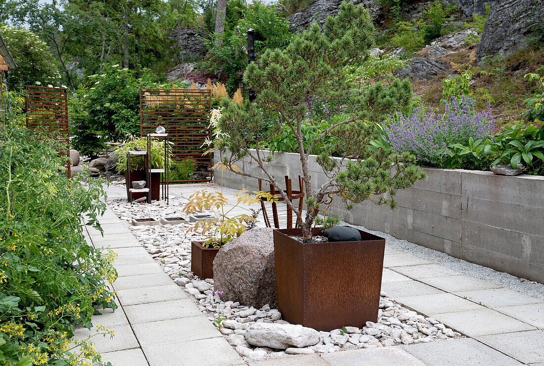 Gartenweg aus Stein mit Pflanzkästen aus Stahl