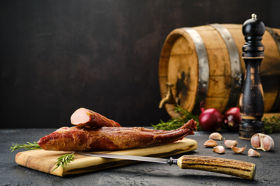 Luftgetrocknetes Lammfleisch auf Holzbrett mit Rosmarin und Gewürzen