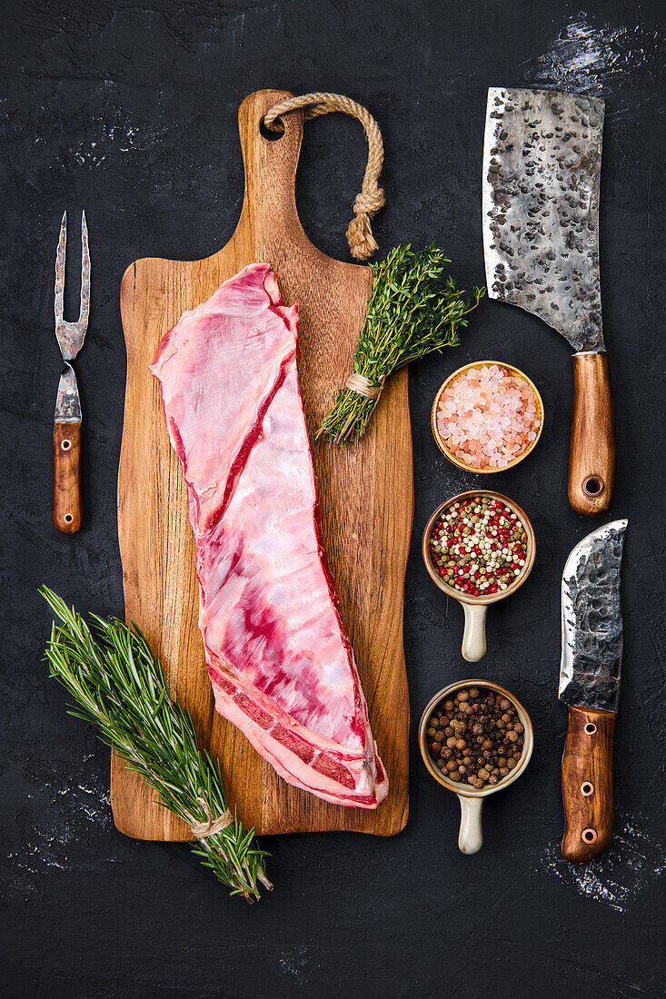 Raw lamb breast with herbs and spices on a cutting board