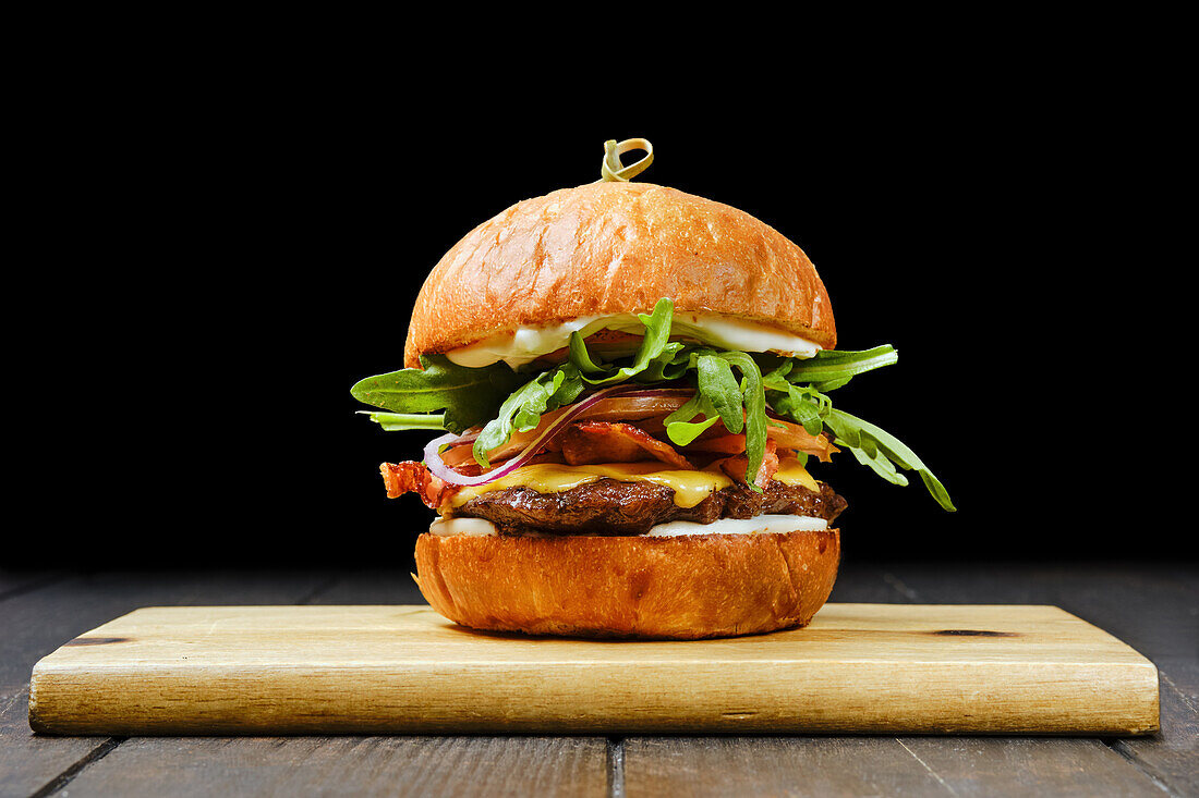 Beef burger with cheese, bacon and rocket