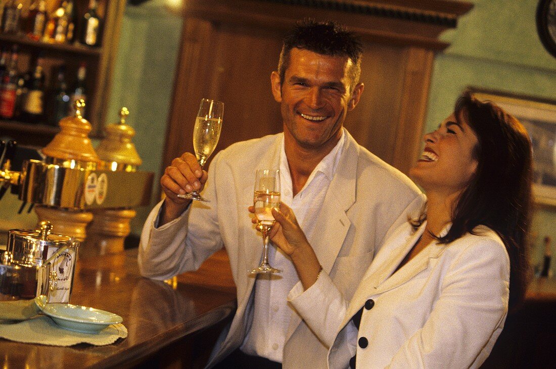 Happy couple with champagne glasses at a bar