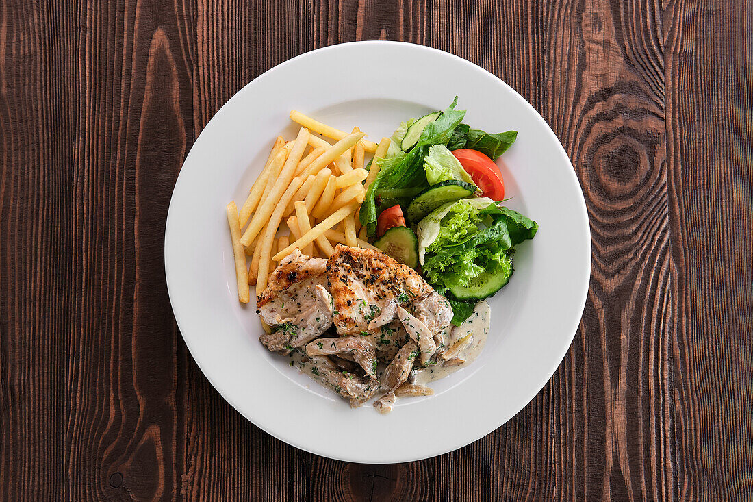 Chicken with oyster mushrooms, chips and vegetables