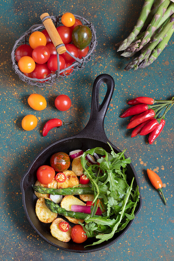 Kartoffelpfanne mit grünem Spargel, Tomaten und Rucola