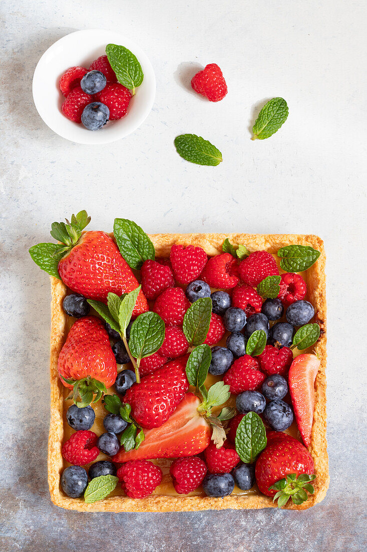 Sommertarte mit frischen Erdbeeren, Blaubeeren und Himbeeren