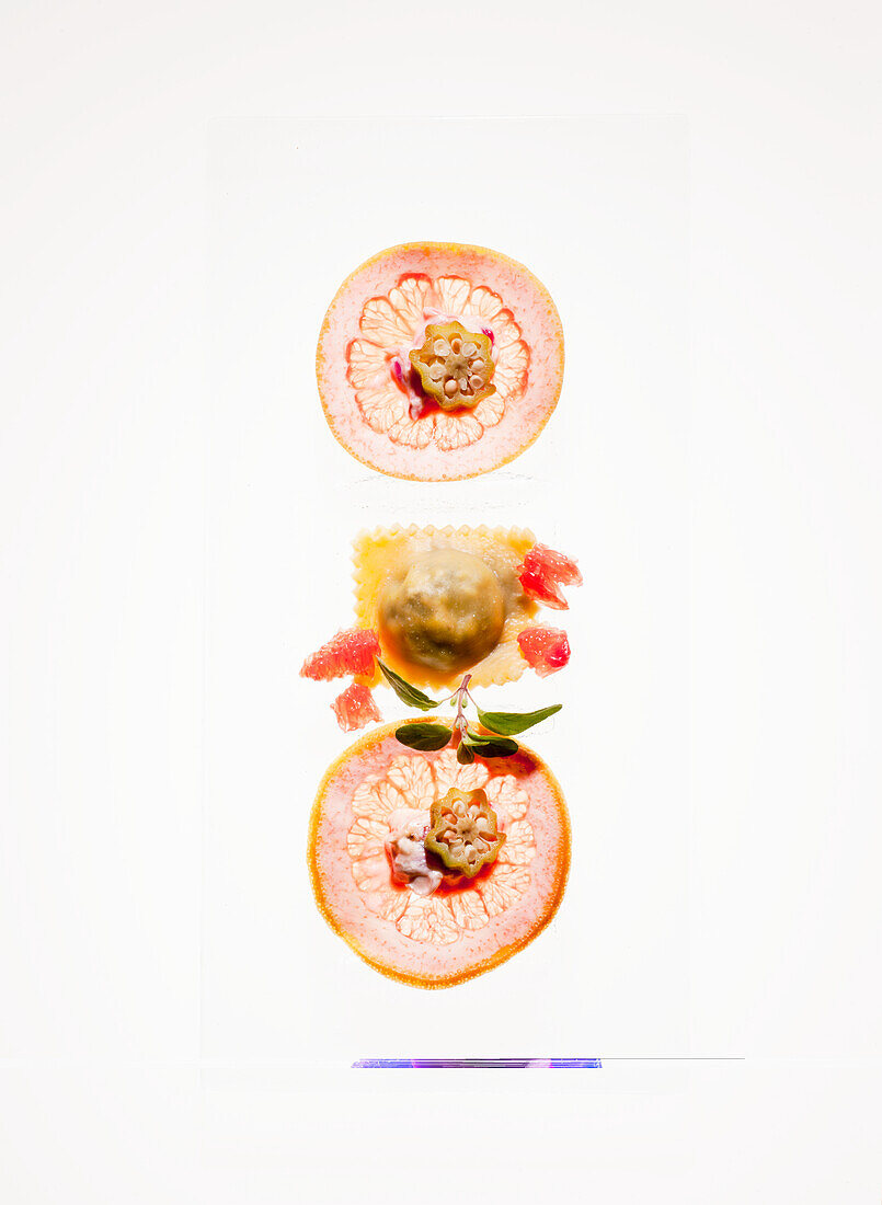 Grapefruit-Scheiben und Ravioli mit Garnitur