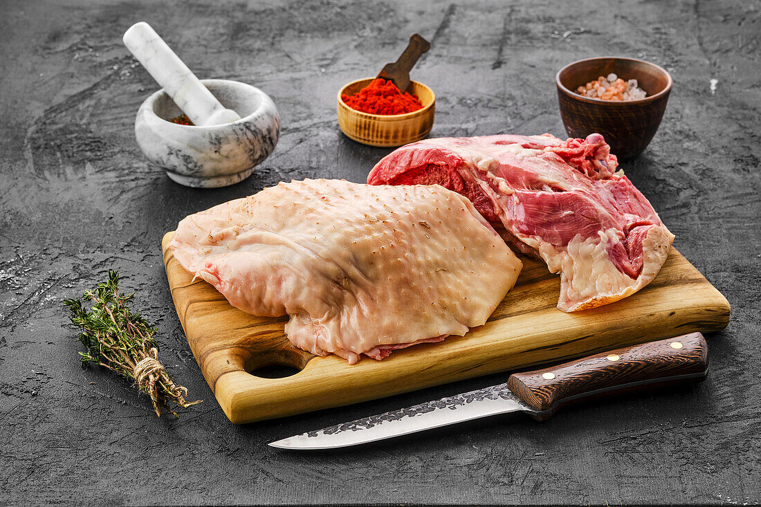 Raw turkey thigh on a chopping board with spices