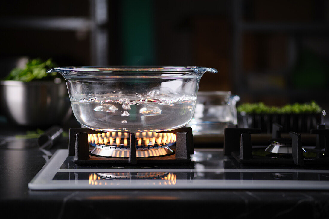 Water boiling in glass jar on gas hob