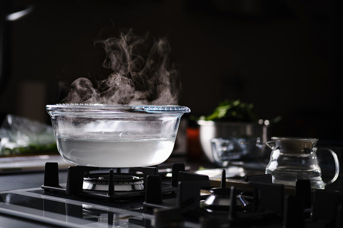 Water boiling in glass jar on gas hob