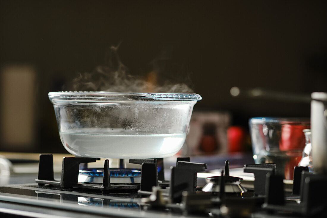 Water boiling in glass jug on gas hob