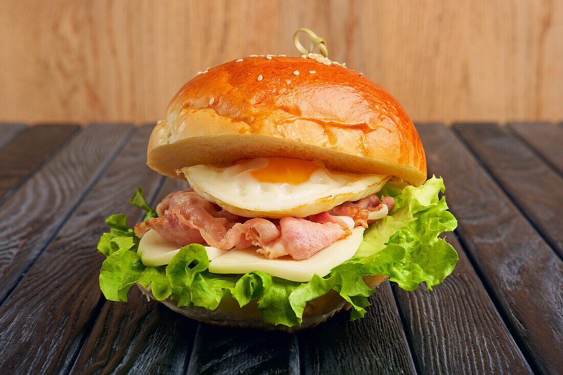 Cheeseburger with fried egg, salad and bacon