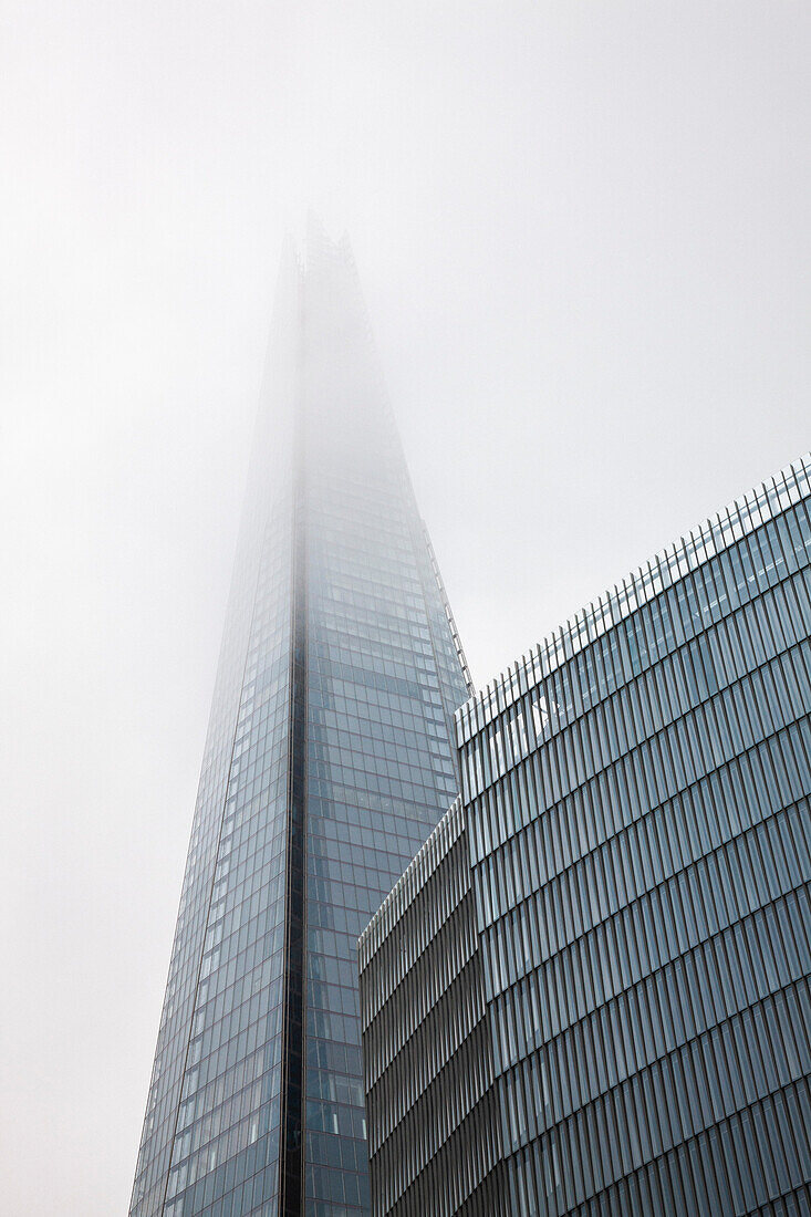 Low angle view of The Shard office building on foggy day, London, England, UK