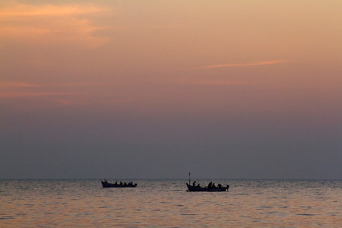 Zwei Fischerboote auf dem Meer bei Sonnenuntergang, Goa, Indien