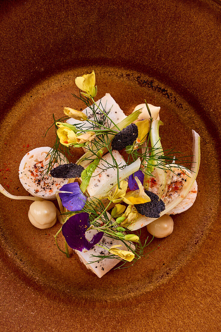 Canneloni mit Taschenkrebs und Tintenfisch, garniert mit Blüten