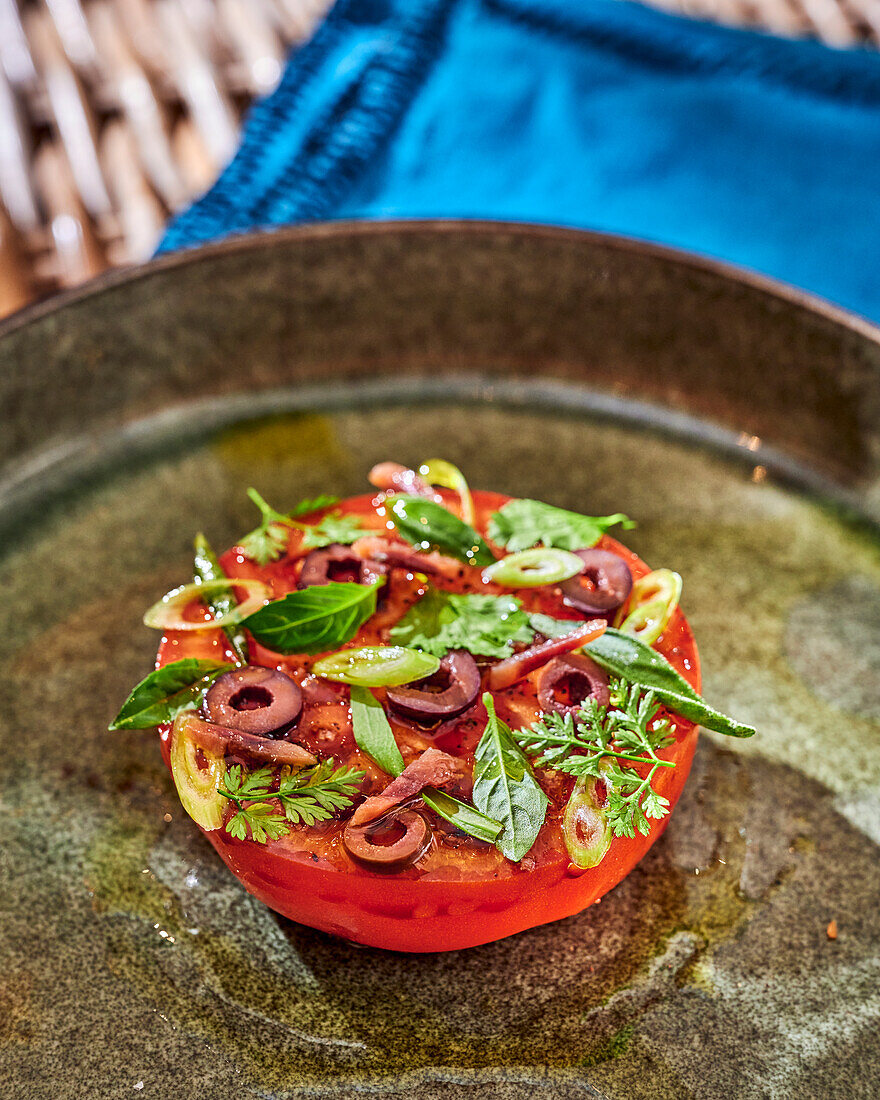 Geröstete Tomate mit Kräutern und schwarzen Oliven