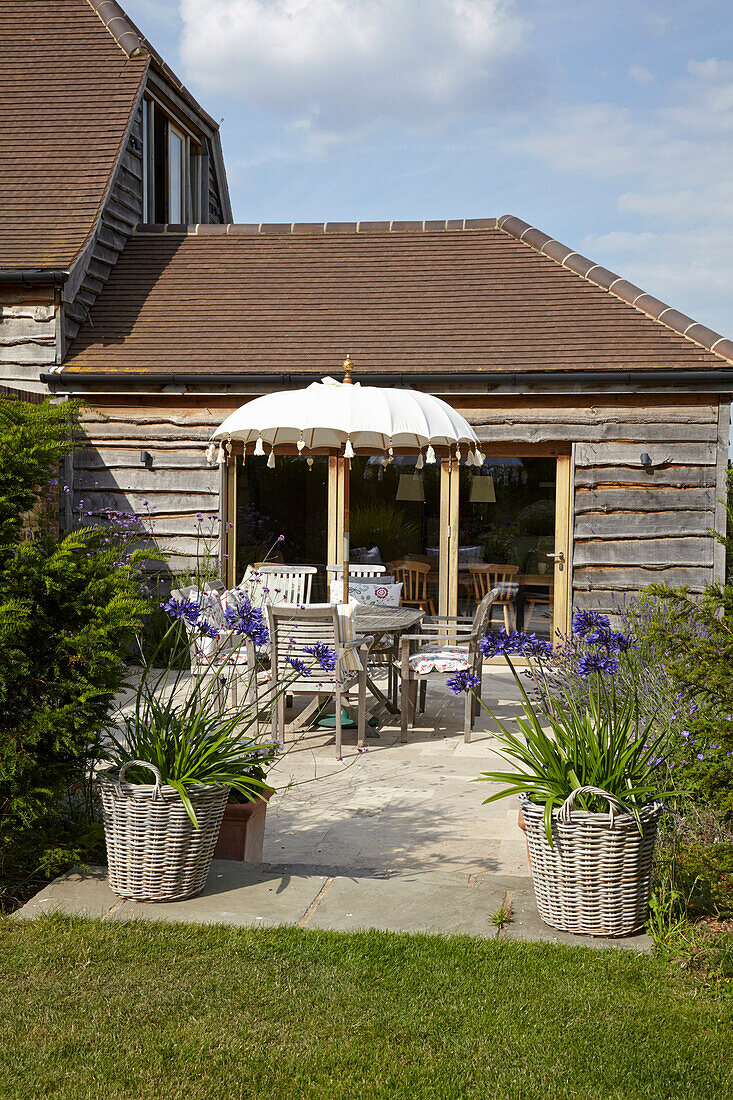 Outdoor dining area with table, chairs, and sun umbrella