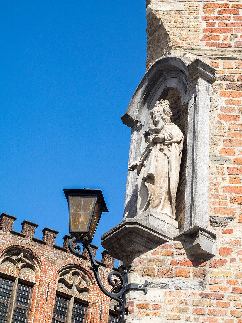 Belgium, Brugge. A stone statue on the cornerstone of a building.