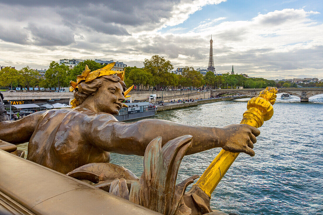 Paris. Nymphes de la Seine statue on Pont Alexandre III, along River Seine. Distant Eiffel Tower.