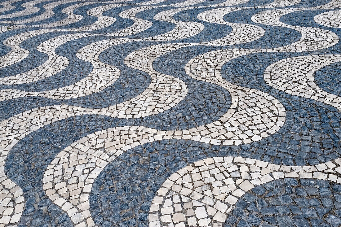 Cascais, Portugal Europe. Typical Portuguese tiled sidewalk in black and white pattern.