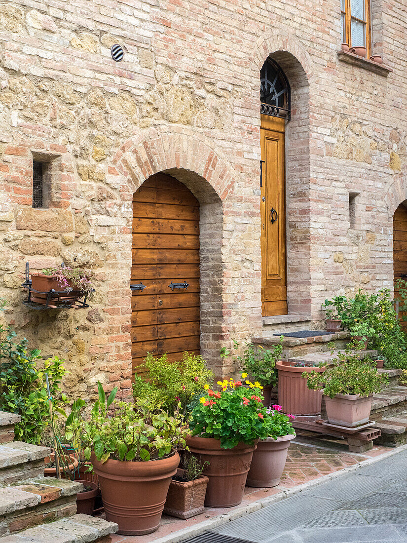 Italien, Toskana, Pienza. Eingangstor umgeben von Blumen.