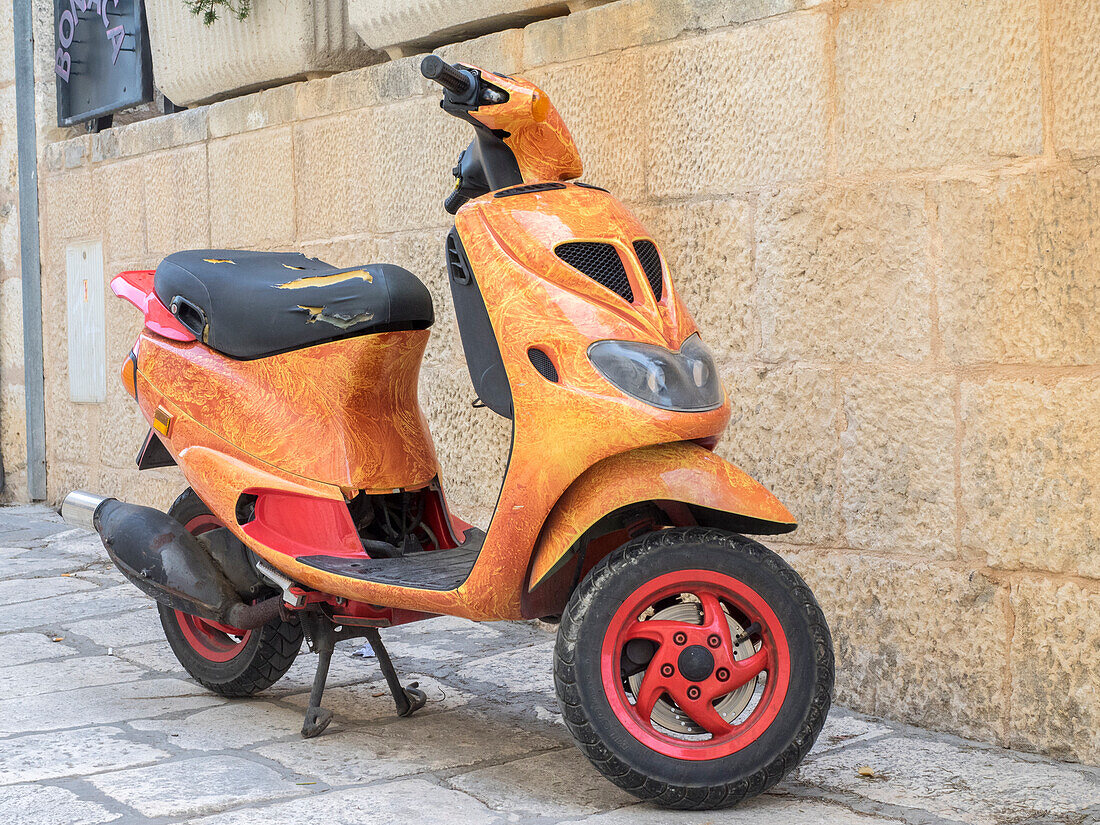 Kroatien, Hvar. Leuchtend orangefarbenes Vespa-Fahrrad in der Stadt Hvar. (Nur für redaktionelle Zwecke)