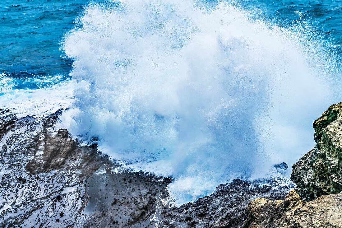 Halona Blowhole Lookout, Oahu, Hawaii. Waves roll in rock formation shoots sea spray in the air