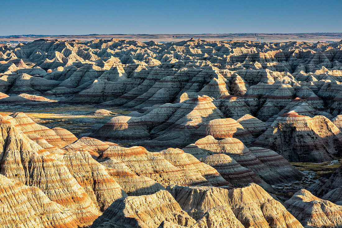 Layers of hoodoo peaks stretching into a flat landscape at the horizon.