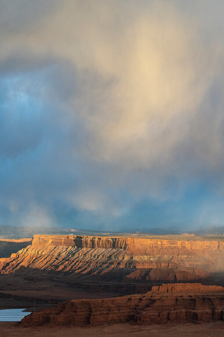 USA, Utah. Storm clouds and breakthrough sunset light on the mesas at Dead Horse Point Overlook, Dead Horse Point State Park.