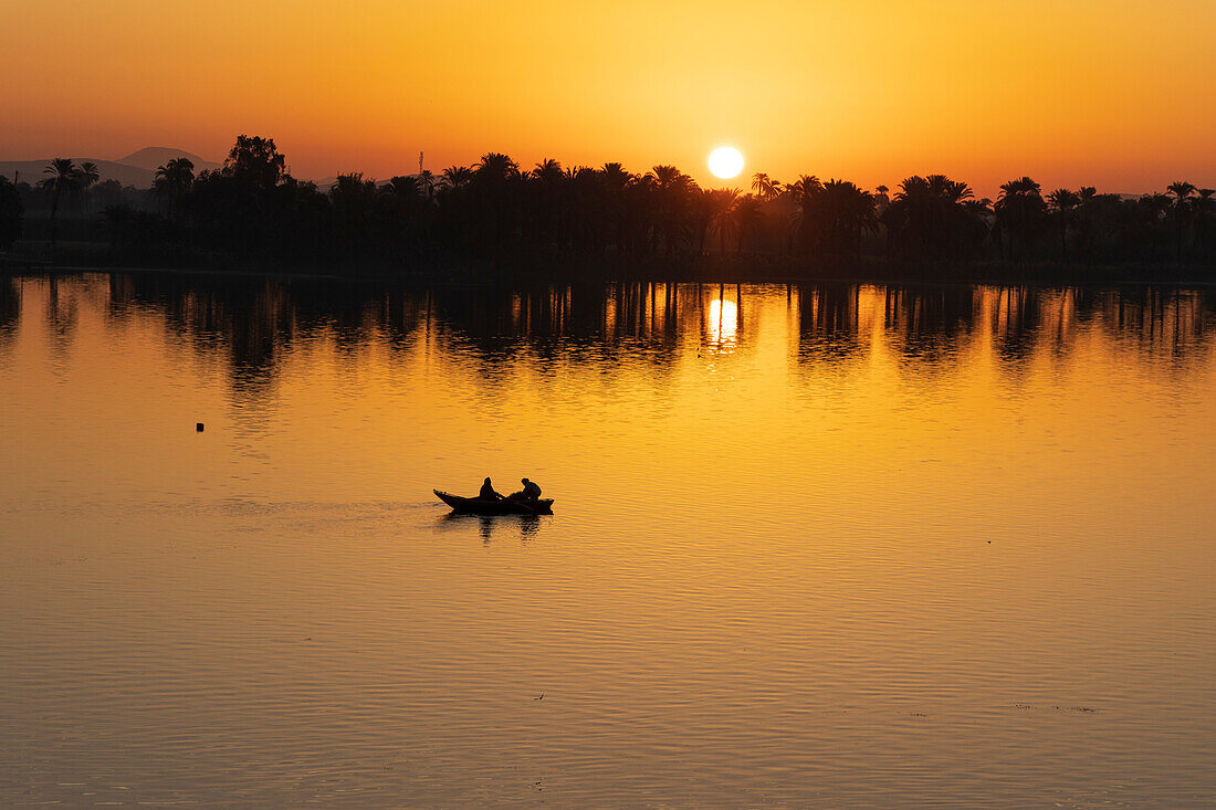 Sonnenaufgang über dem Nil bei dem Dorf Esna, Ägypten.